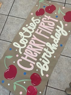 a sign on the ground with cherries painted on it