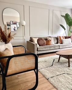 a living room filled with furniture and a mirror on the wall above it's headboard