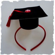 a black graduation hat with red ribbon on it