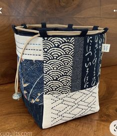 a blue and white tote bag sitting on top of a wooden table