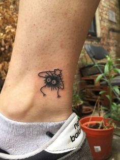 a small black and white tattoo on the ankle