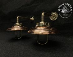 two brass - plated wall lights on black background with caption that reads stanver nautirator