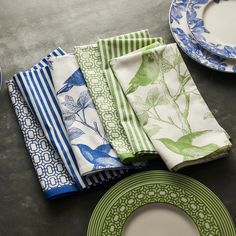 a table topped with plates and napkins next to each other