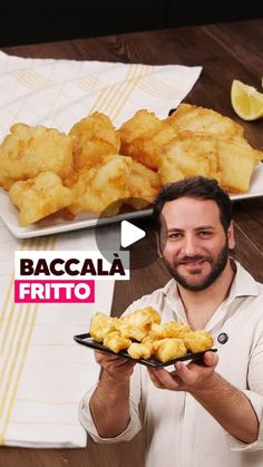 a man holding a plate of food with lemons on the table in front of him