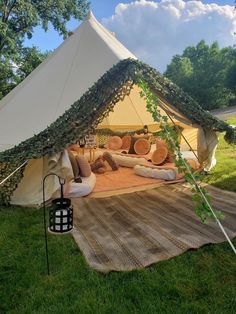 a tent set up in the grass with pillows on it