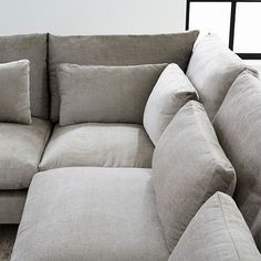 a couch with pillows on it and the words harmony down - filled shaped sectional above it