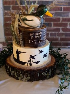 a cake with a duck sitting on top of it next to a sign that says the hunt is over