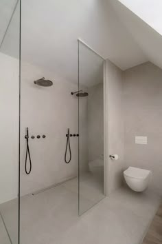 a bathroom with a toilet, shower and glass walls in it's center area