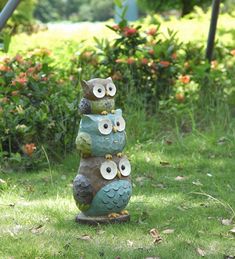 an owl statue sitting on top of a lush green field