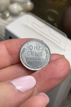 a person holding a one cent coin in their hand