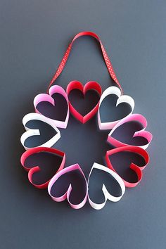 several heart shaped paper hangings on a gray surface