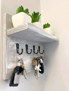 a white shelf with keys and plants on it