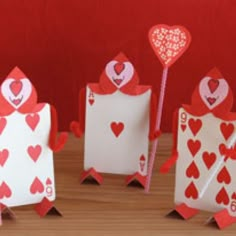 two cards with hearts on them, one holding a stick and the other holding a heart