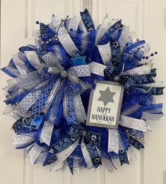 a blue and white wreath with happy hanukkah written on it