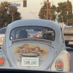 an old car is painted with cherubs on it's hood and the license plate says tam love