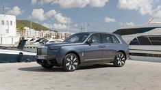 a silver car is parked in front of some boats