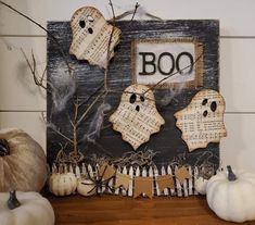 halloween decorations are displayed on the mantle in front of a wooden sign with boo written on it