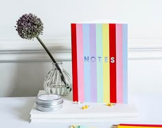 a note book sitting on top of a table next to a flower