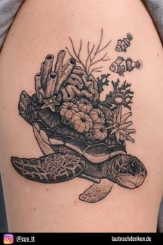 a woman's arm with a turtle and coral tattoo on it