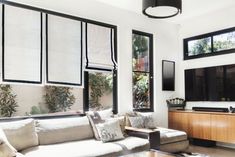 a living room filled with furniture and large windows