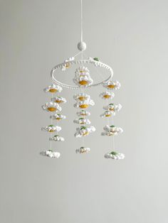 a white chandelier with flowers hanging from it's sides on a gray wall