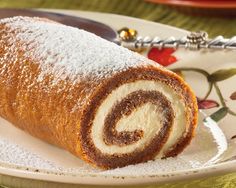 a roll on a plate covered in powdered sugar