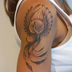 a woman's arm with a tattoo on it that has an image of a bird