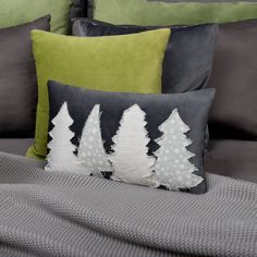 the pillows are decorated with white and green trees