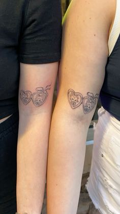 two women with matching tattoos on their arms