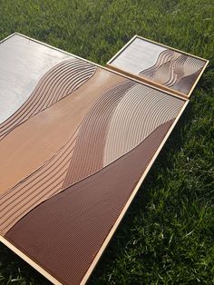 two mirrors sitting in the grass on top of each other with wavy lines painted on them