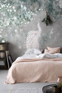 a bedroom decorated in pink and white with a large wallpapered mural behind the bed