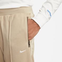 Style No. DQ4996-247 Color: Khaki/White Nike obsessed over the fabrics, details and craft to transform them into a streetwear staple you can wear anywhere. Soft blended poly-knit fabric feels smooth against your skin for daily comfort. Standard fit for a relaxed, easy feel. Zippered hand pockets. Elastic waistband with drawcord. 62% Cotton/38% Polyester. Nike Sportswear Authentics Men's Track Pants. White Nike, Color Khaki, White Nikes, Nike Sportswear, Track Pants, Your Skin, Knitted Fabric, Knit Fabric, Track