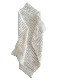 the white knitted blanket is folded on top of it's back and side