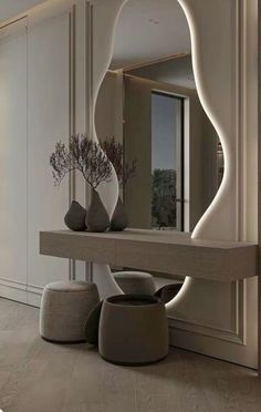 a large mirror sitting on top of a wooden table next to a vase filled with flowers