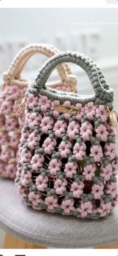 two crocheted purses sitting on top of a table next to each other