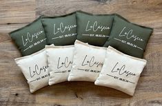 five personalized pillows with names on them sitting on a wooden table in front of a wood floor