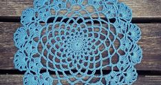 a crocheted doily on a wooden surface