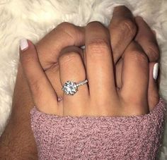 a woman's hand with a ring on her finger and a white manicure