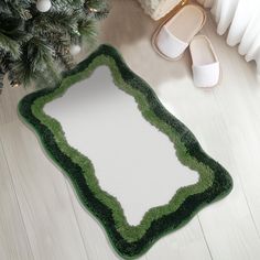 a green and white area rug on the floor next to a pair of slippers