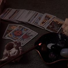 a table topped with cards and toys on top of a floor next to a candle