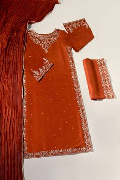 Meticulously crafted from a remarkably glamourous shade of burnt orange ( pure raw silk 60 gms )“ Minaree “ with its intricate zari details strikes the perfect balance between elegant and eye-catching, making this beautiful design a must have. The length of the long kameez is 46 inches.Agha Noor’s style tip - “ Style w Elegant Red Salwar Kameez With Cutdana, Orange Silk Sets With Cutdana, Orange Silk Sets With Cutdana Details, Red Tissue Silk Kurta With Traditional Drape, Semi-stitched Orange Silk Sets, Semi-stitched Silk Sets In Orange, Orange Silk Traditional Wear With Resham Embroidery, Red Tissue Silk Kurta With Zari Work, Orange Traditional Wear With Dabka Work