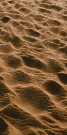 the sand is brown in color and it looks like waves