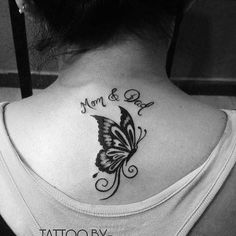 a woman with a butterfly tattoo on her back shoulder and the words mom and dad written in black ink