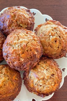 a white plate topped with muffins on top of a wooden table