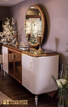 a mirror on top of a dresser next to a vase with flowers and other items