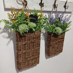 two wicker baskets with plants in them hanging from hooks on the wall next to each other