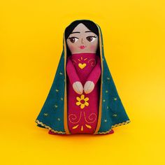 a doll in a red and green outfit on a yellow background with stars around it