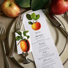 a menu card with an apple on it next to silverware and apples in the background