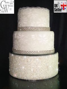 three tiered wedding cake with white frosting and sparkles on the top layer