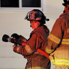 two fire fighters standing in front of a house